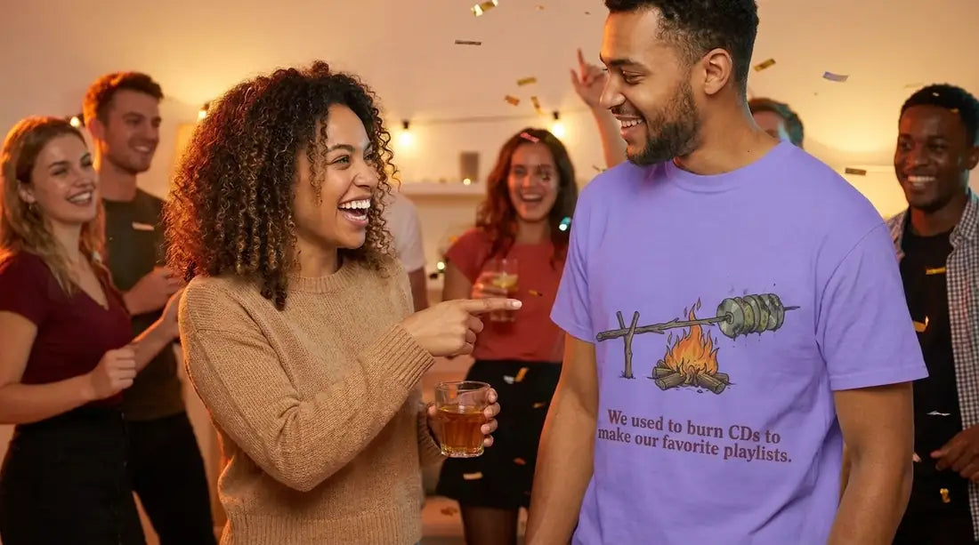 Friends laughing together at a house party. One of them wears the purple Cool Millennialz tee that reads: We used to burn CDs to make our favorite playlists.